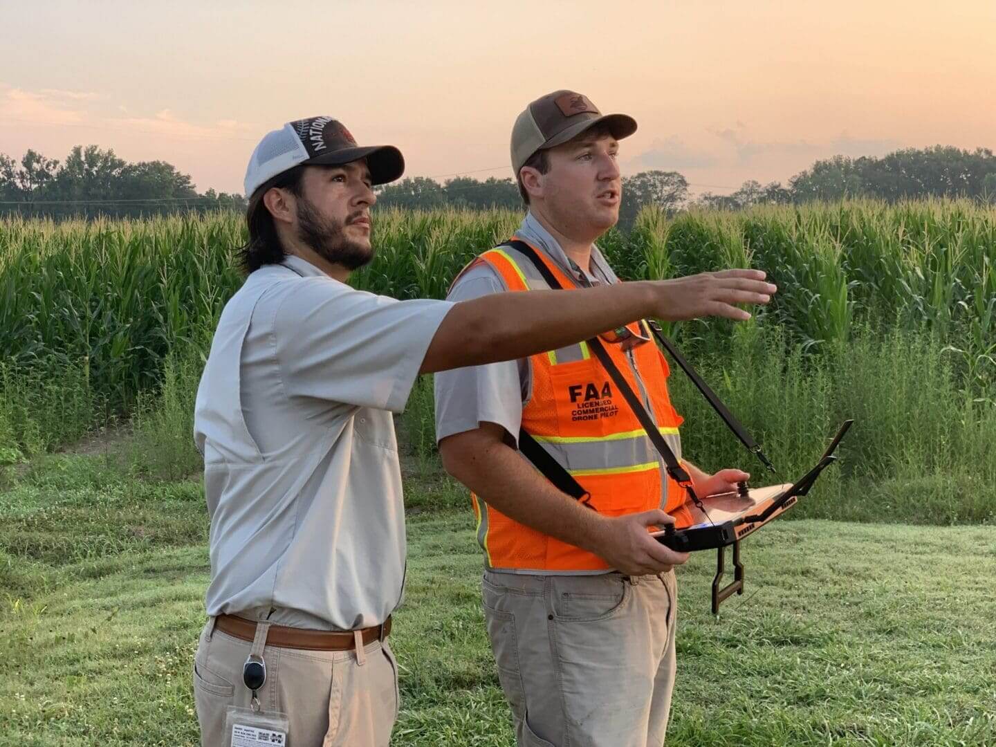 Two men operating a drone near field.